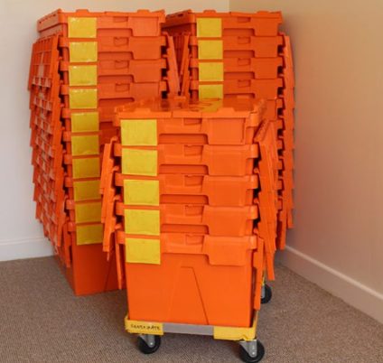 Reusable moving crates stacked on a wheeled trolley